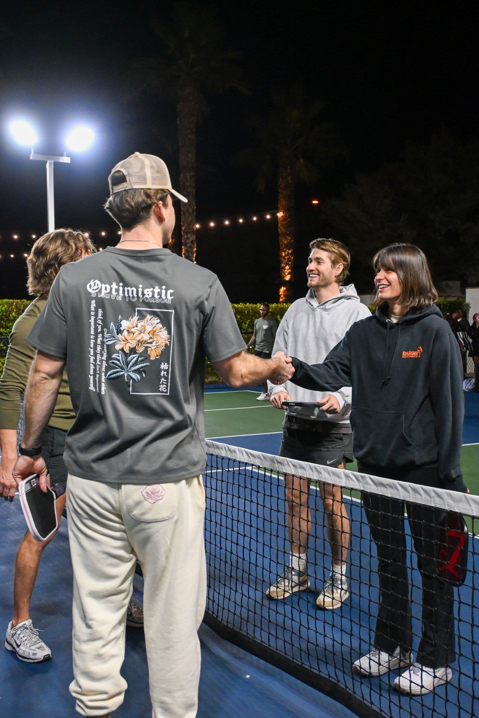 Players greet each other across a pickleball net after a game.